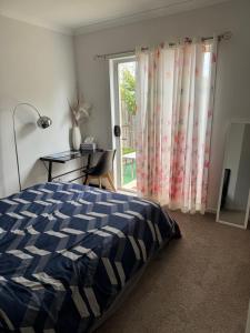 a bedroom with a bed and a window and a desk at Quiet and Cozy Room in Geelong