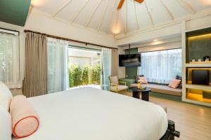 a bedroom with a white bed and a living room at Davinia Hua Hin Resort in Hua Hin