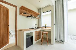 a small kitchen with a counter and a stool at Soma House - Adults Only in Kuta Lombok