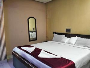 a bedroom with a large white bed with a mirror at Coorg point in Madikeri