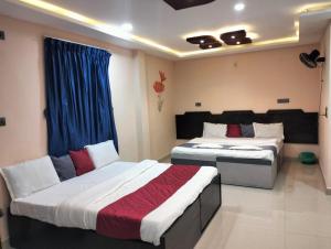 a bedroom with two beds and a window at Coorg point in Madikeri