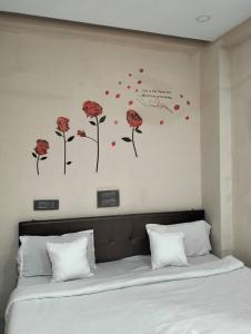a bedroom with a bed with red flowers on the wall at Coorg point in Madikeri