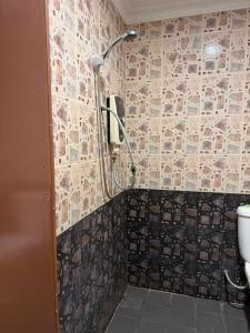 a bathroom with a shower with a toilet and a phone at Jam Hotel Nilai in Nilai