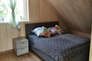 a bedroom with a bed and a nightstand and a window at Comfortable holiday home, pool, sauna, jacuzzi in Brzuze +28 photos