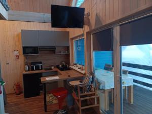 a room with a kitchen with a desk and a table at Comfortable holiday home, pool, sauna, jacuzzi in Brzuze