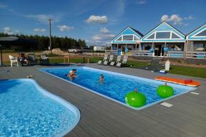 a swimming pool with two people in the water at Comfortable holiday home, pool, sauna, jacuzzi in Brzuze