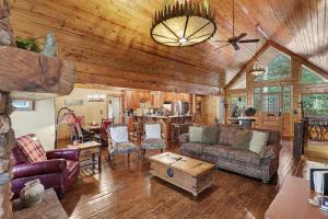 a living room with a couch and a table at Vintage Luxury Mountain Cabin, Creekside, King Bed, Spa, Fire Pit, Game Room, DogsOk in Hiawassee