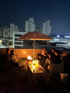 a group of people sitting around a table with an umbrella at Dontan terrace in Hwaseong +24 photos