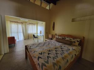 a bedroom with a bed and a table with a chair at A Serene Get Away in Vieux Fort