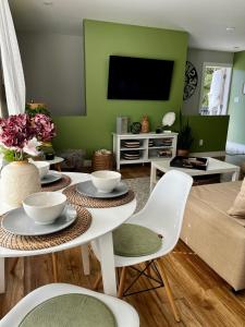 ein Wohnzimmer mit grünen Wänden und einem Tisch mit Stühlen in der Unterkunft Modern Maple Flat in Maple Ridge District Municipality