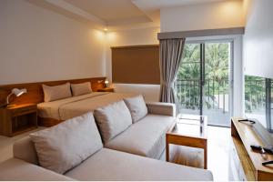 a living room with a couch and a bed at La Cha Cha Residence in Ban Thalat Choeng Thale