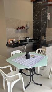 a kitchen with a table with chairs and a stove at Vista Bela Guesthouse in Barra do Garças