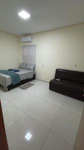 a bedroom with a bed and a tiled floor at Vista Bela Guesthouse in Barra do Garças