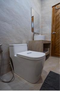 a bathroom with a toilet and a sink at La Cha Cha Residence in Ban Thalat Choeng Thale +16 photos