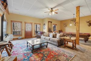 a living room with a couch and a table at Vintage Luxury Mountain Cabin, Creekside, King Bed, Spa, Fire Pit, Game Room, DogsOk in Hiawassee