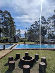 a fountain in front of a swimming pool with trees at Artana cabin in Palayangan