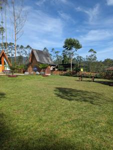 a large grass field with a barn in the background at Artana cabin in Palayangan +3 photos