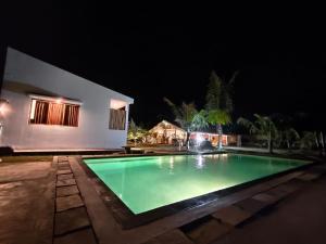 a swimming pool in front of a house at night at Alden Beach House in Sekotong
