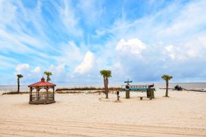 a beach with a gazebo and palm trees on it at Biloxi Coastal Haven Walk to Beach in Biloxi