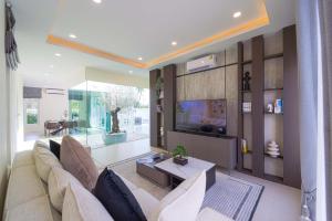 a living room with a couch and a tv at 3BR Luxury Pool Villa, Hua Hin (TP3) in Hua Hin