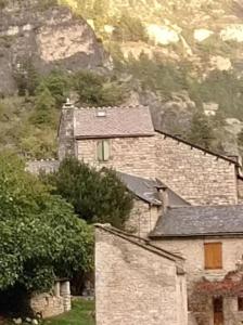 a group of buildings with a mountain in the background at L'impasse de la courtasse in Sainte-Énimie