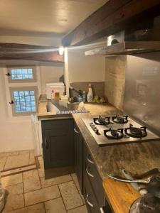 a kitchen with a stove and a counter top at L'impasse de la courtasse in Sainte-Énimie +6 photos