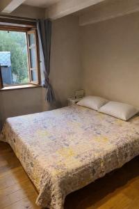 a bedroom with a large bed with a window at L'impasse de la courtasse in Sainte-Énimie