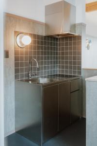 eine Küche mit Spüle und gefliester Wand in der Unterkunft Hotel egne in Hizume + 43 Fotos