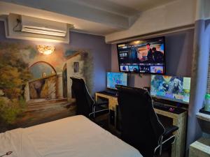 a room with a bed and chairs and a tv at Amant Hotel in Goyang