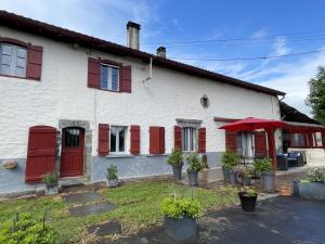 a white house with red shutters at Chambre argoitzia in Saint-Martin-dʼArberoue