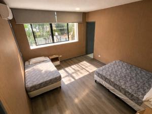 a bedroom with two beds and a window at CulturaHumana Guesthouse in Panama City +64 photos