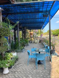 a patio with blue chairs and tables and plants at Ocean Breeze Hotel in Kep