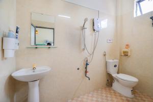 a bathroom with a shower and a toilet and a sink at Y's La House in Hoi An +29 photos