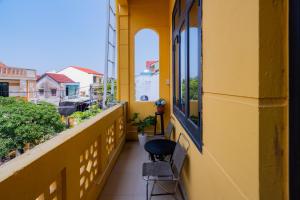 a balcony with a chair and a window at Y's La House in Hoi An