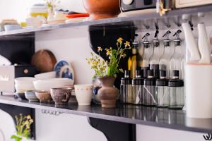 a shelf with a bunch of dishes and bottles at Y's La House in Hoi An