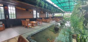 a restaurant with a pool of water and tables and chairs at Hotel Suối Cao in Phú Quốc