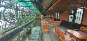 an empty restaurant with tables and chairs and a pond at Hotel Suối Cao in Phú Quốc