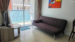 a living room with a couch next to a window at Grandblue condominium 405,406 in Ban Tha Fat