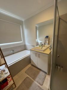 a bathroom with a tub and a sink and a shower at Quiet and Cozy Room in Geelong +7 photos