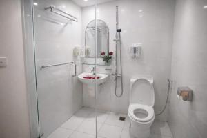 a white bathroom with a toilet and a sink at Eco Nest Hotel 6 Đình Ngang in Hanoi