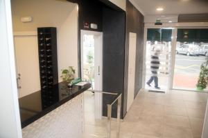 a hallway with a glass door and a person walking through a window at Hostal El Altet in El Alted