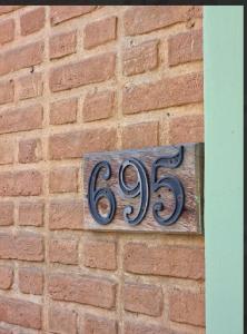 a sign on the side of a brick wall at Horizon 2 andar in Marataizes