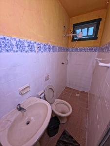 a bathroom with a toilet and a sink at Horizon 2 andar in Marataizes