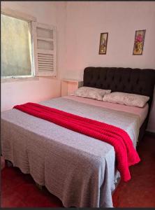 a bedroom with a bed with a red blanket on it at Horizon 2 andar in Marataizes