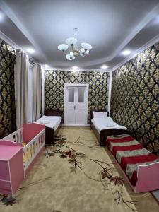 a room with two beds and a crib at Uyut house in Samarkand