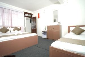 a hotel room with two beds and a bathroom at Himavati Retreat in Darjeeling