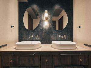 two sinks in a bathroom with two mirrors at illi Noa Hamamatsucho in Tokyo +66 photos