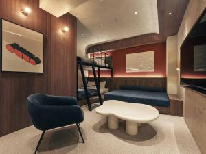 a living room with a staircase and a chair and a stool at illi Noa Hamamatsucho in Tokyo