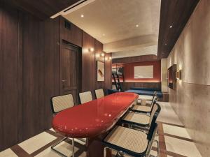 a red table and chairs in a room at illi Noa Hamamatsucho in Tokyo