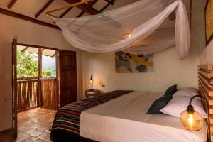 a bedroom with a bed with a mosquito net at Romantic Colonial Charm Barichara w Jacuzzi in Barichara